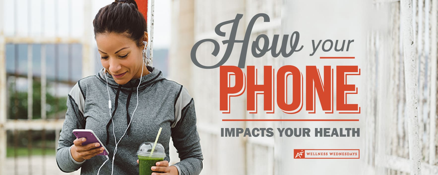 Woman looks at iphone while drinking smoothie