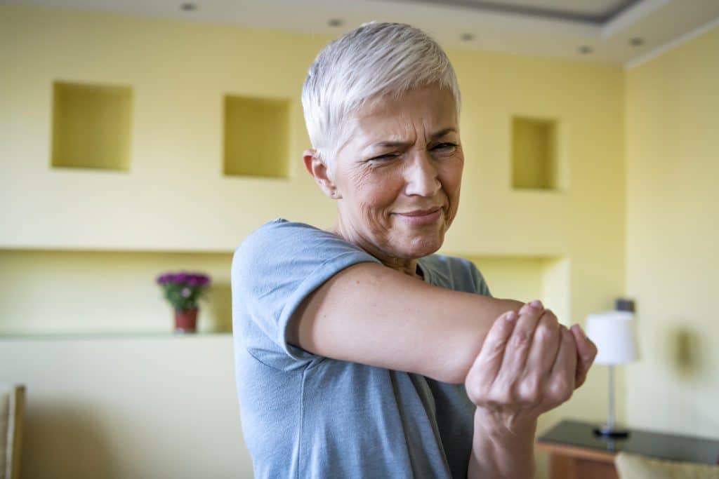 mature woman holding her elbow