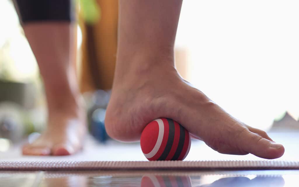 Person doing lacrosse ball exercises for plantar fasciitis treatment