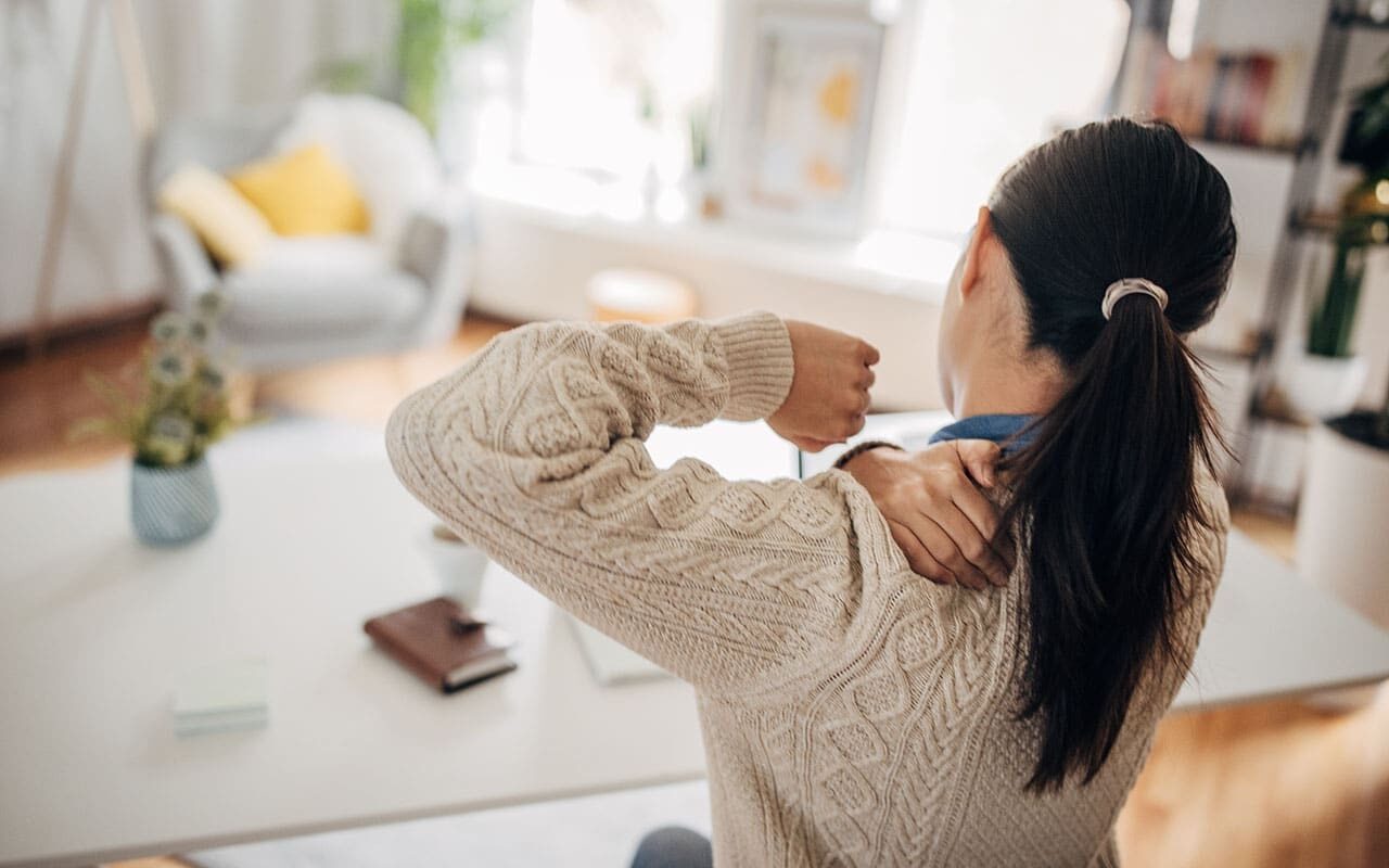 Woman Grabbing Her Upper Back in Pain