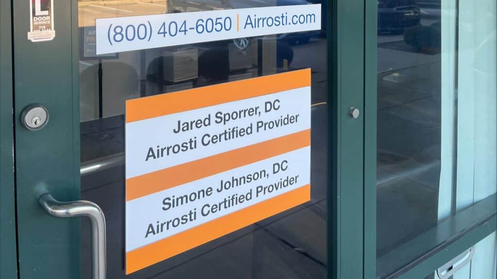 The front entrance to Airrosti Fairfield Village, showing the names of Drs. Sporrer and Johnson, both of whom are the office's Airrosti Certified Providers.