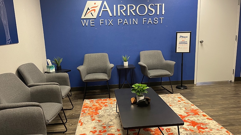 photo of the lobby at Airrosti Fort Worth. Airrosti logo is decorating the wall