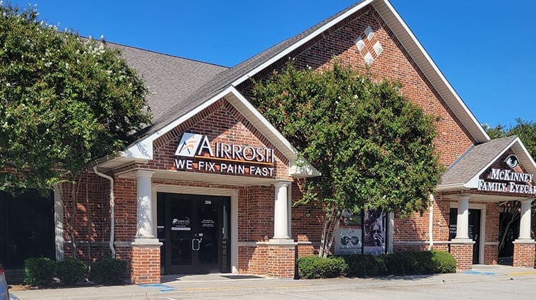 photo of the building exterior and front entrance of Airrosti McKinney. Airrosti signage is visible above entryway