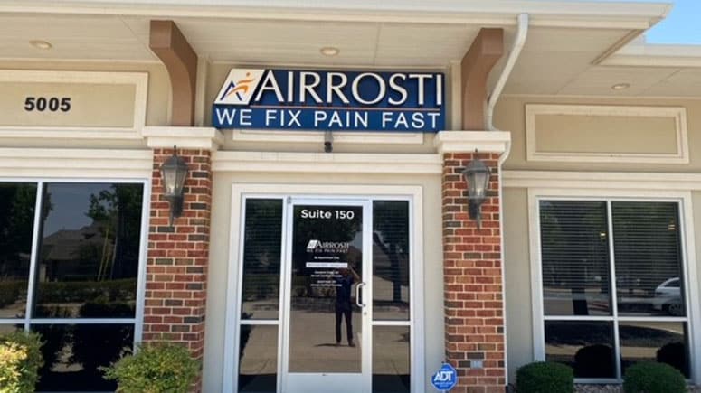 The front entrance of Airrosti Colleyville showing the sign and building exterior.