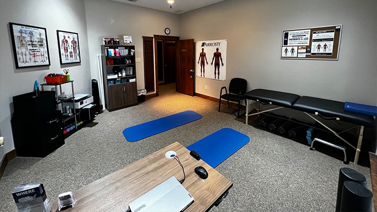 A photo showing the inside recovery room at Airrosti Main Place. Exercise mats and foam rollers are visible in the room
