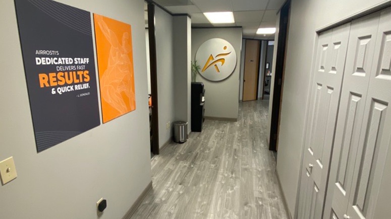 A look inside the hallway of the Airrosti Tanglewood suite. The Airrosti logo is prominently displayed on the wall.