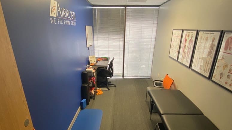 A view of the recovery room inside Airrosti Tanglewood. A treatment table and various exercise related equipment are within view.