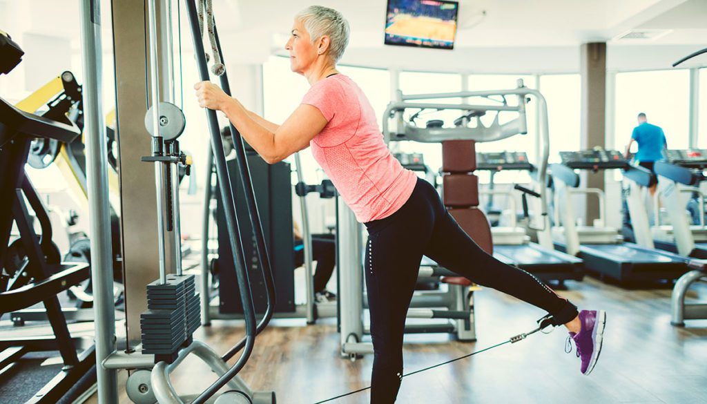 Mature Woman Exercising In Gym.