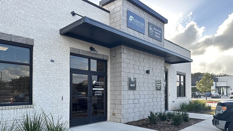 An exterior view of the Airrosti Katy building, showing Airrosti Katy next to Memorial Health Urgent Care and Infusions.