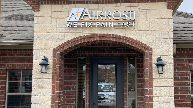 The building exterior of Airrosti Southlake. The Airrosti logo is prominently visible above the entryway.