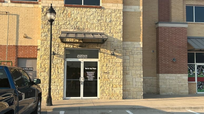 An outside view photo of the Airrosti Frisco Square building. A suite number, 5566, is visible over the doors.