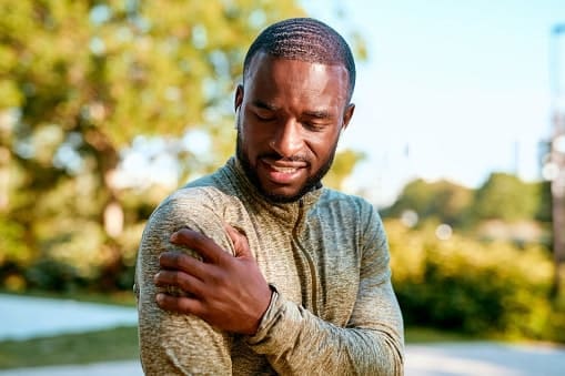 Man holding shoulder in pain
