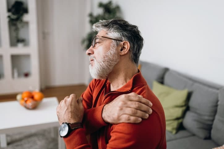 Man holding shoulder in pain