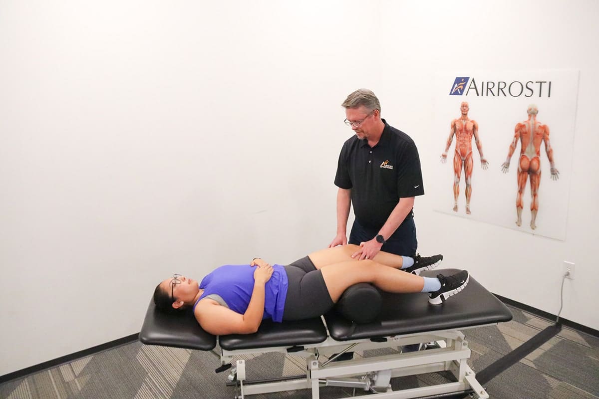 Airrosti provider treating a patient with knee pain
