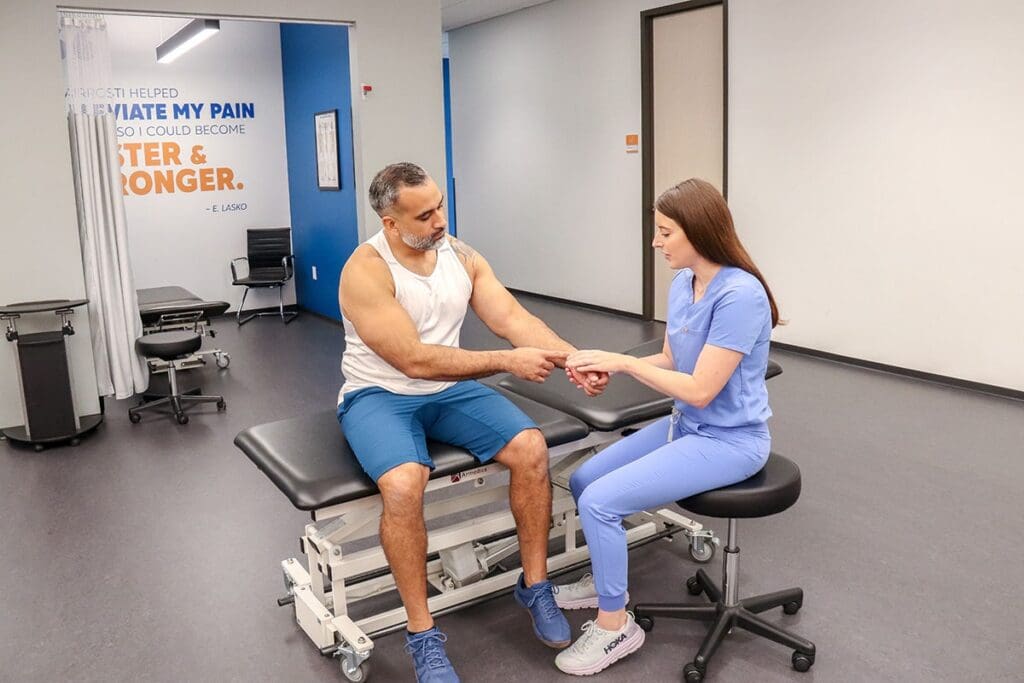 Airrosti Provider Treating Patient with wrist pain in Airrosti Treatment Room