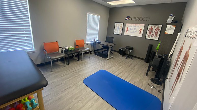 An interior view of the recovery room inside Airrosti Deer Park showing exercise mats, stretching and strength equipment.
