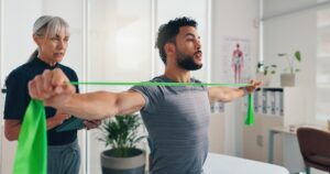 man doing upper back rehab exercises with Airrosti Provider
