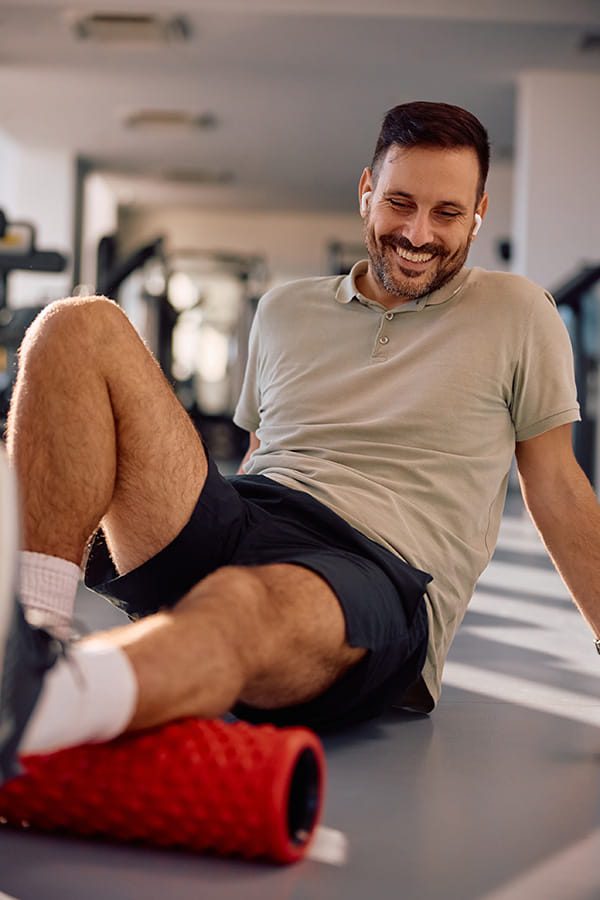 man rolling his calf on a foam roller