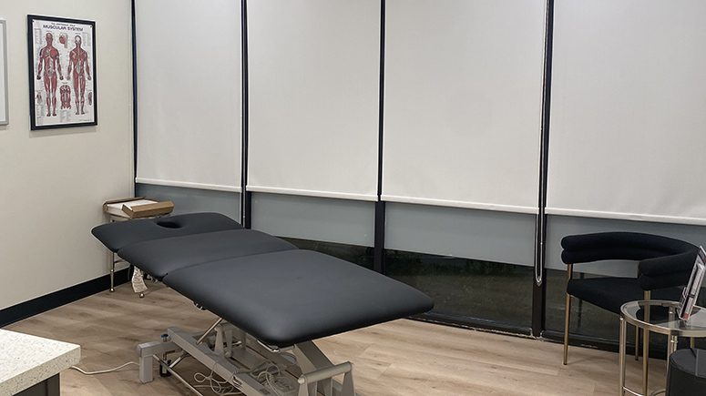 The treatment room inside Airrosti Weslaco, showing the treatment table in the center of the room.