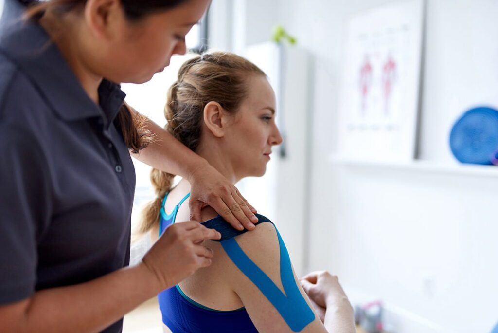 Provider putting K Tape on patient