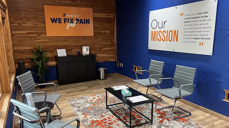 The lobby inside Airrosti Cedar Hill, showing a blue accent wall, chairs, and the reception desk.